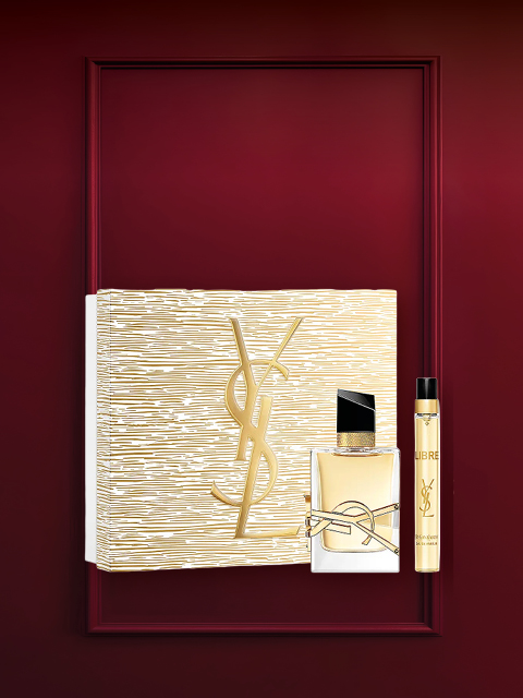 Set regalo profumato in una cornice rosso scuro con una scatola a motivi floreali, un piccolo flacone di profumo e un tubetto bianco con tappo dorato. In alto, in caratteri bianchi, si legge "Set profumo".