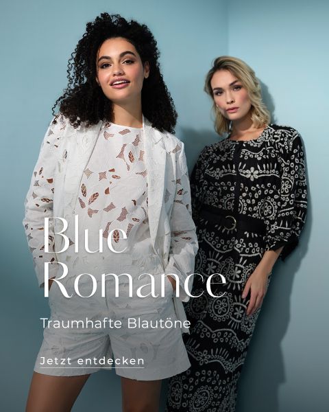 Due donne presentano outfit alla moda davanti a una parete azzurra. Una indossa un completo floreale bianco, l'altra un abito a motivi bianchi e neri. Il testo recita: "Blue Romance, Sognanti tonalità di blu. Scopri ora."